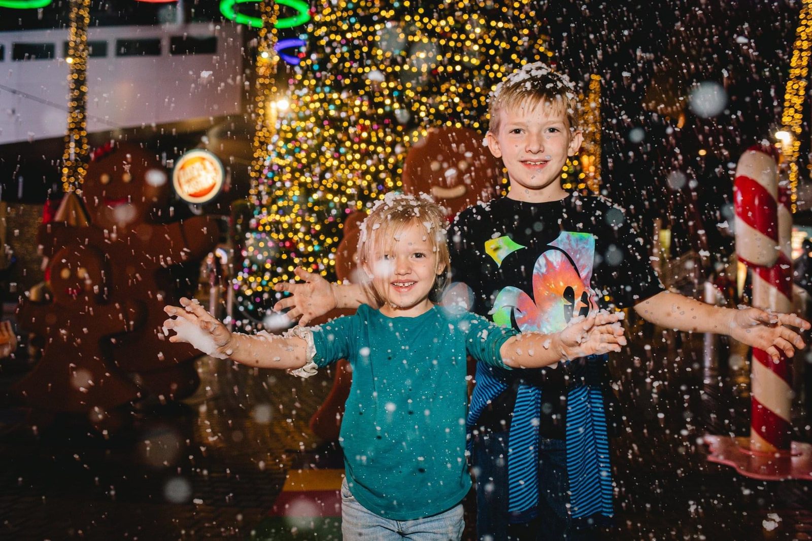 Children reaching up to catch falling snow at a Nor'Easter Snow Effects event